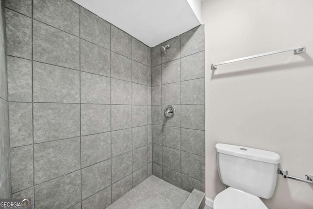 bathroom with tiled shower and toilet