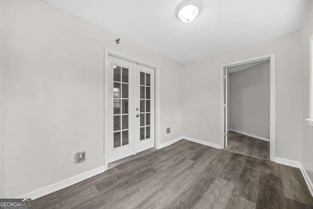 empty room with dark hardwood / wood-style flooring and french doors