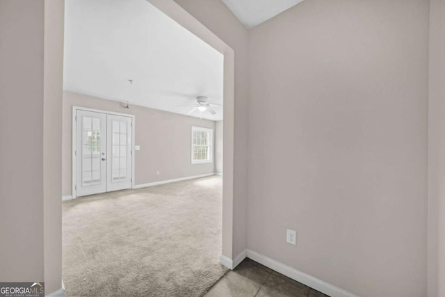 carpeted empty room featuring ceiling fan and french doors