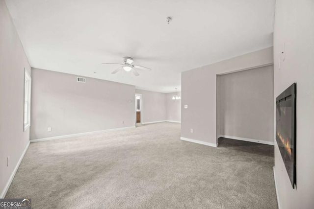 unfurnished living room with carpet, a healthy amount of sunlight, and ceiling fan