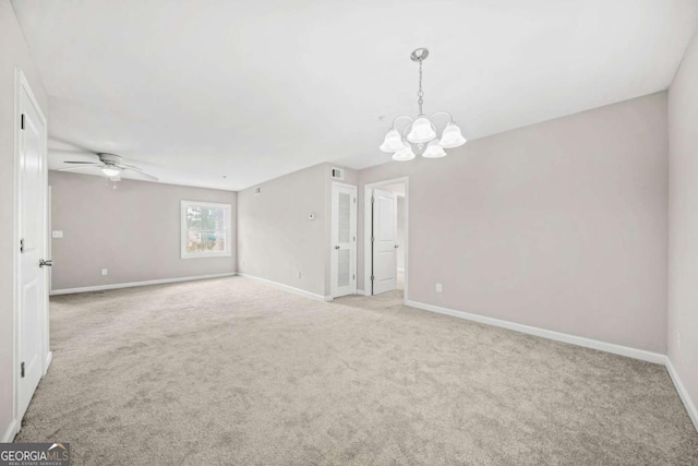 spare room with light colored carpet and ceiling fan with notable chandelier