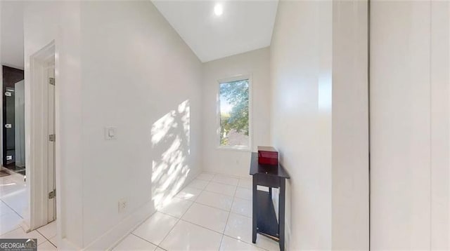 corridor with light tile patterned floors and baseboards