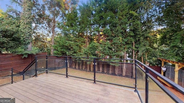 wooden deck with a fenced backyard