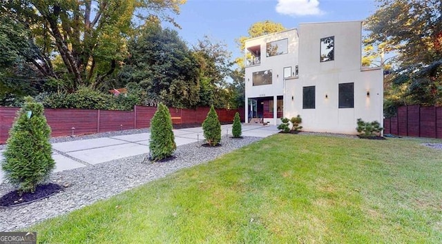 view of front of property featuring stucco siding, a front yard, and fence