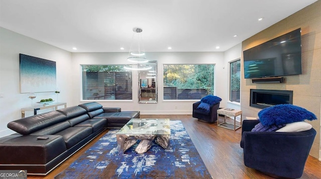 living room featuring recessed lighting, a large fireplace, and wood finished floors