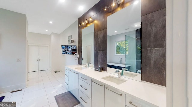 bathroom featuring a soaking tub, double vanity, tile patterned floors, and a sink