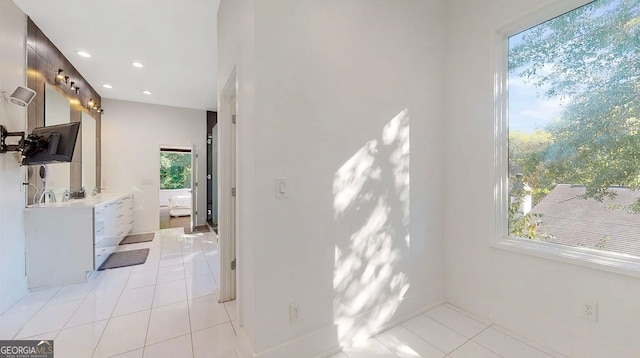 hall featuring light tile patterned floors and recessed lighting