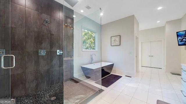 bathroom featuring visible vents, baseboards, a freestanding bath, and a shower stall