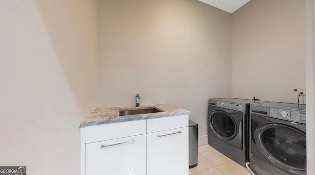 clothes washing area with cabinet space, light tile patterned floors, separate washer and dryer, and a sink