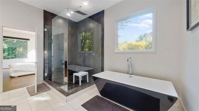 ensuite bathroom featuring a shower stall, a healthy amount of sunlight, tile patterned floors, and connected bathroom