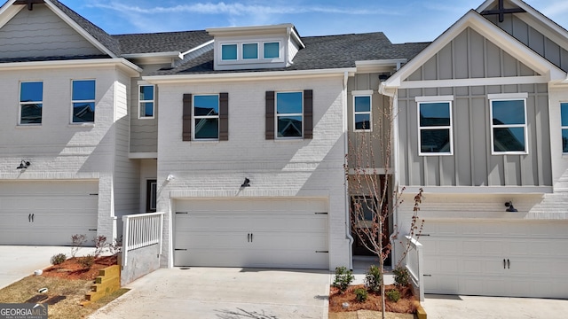 multi unit property with concrete driveway, an attached garage, brick siding, and board and batten siding