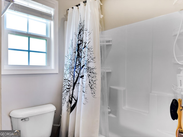 bathroom featuring a shower with curtain and toilet