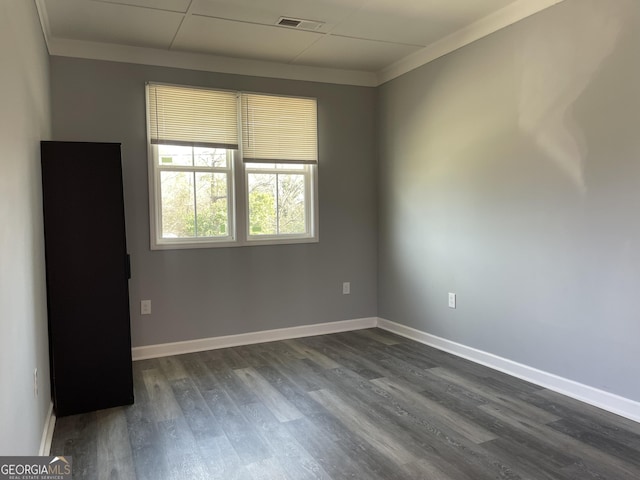 empty room with ornamental molding and dark hardwood / wood-style flooring