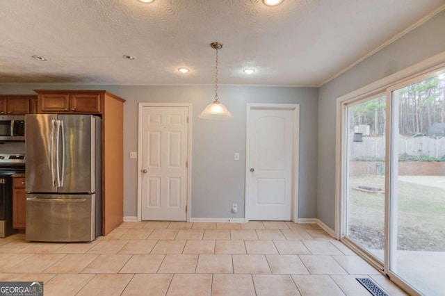 kitchen featuring brown cabinets, decorative light fixtures, appliances with stainless steel finishes, a textured ceiling, and baseboards