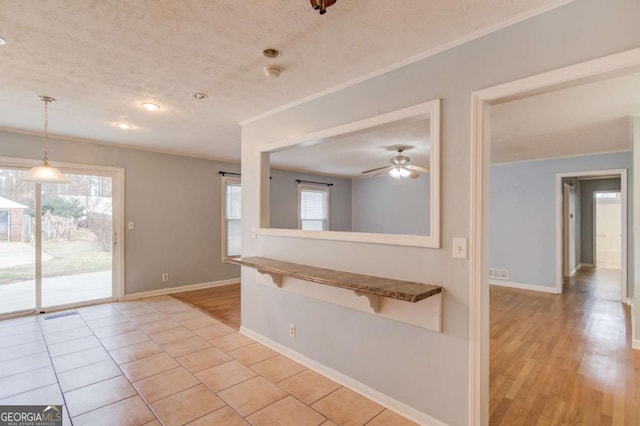 interior space with light tile patterned floors, visible vents, baseboards, and a textured ceiling