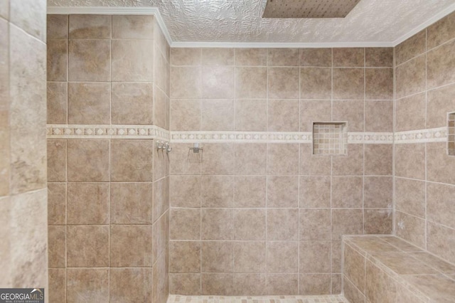 full bath featuring ornamental molding, tiled shower, and a textured ceiling