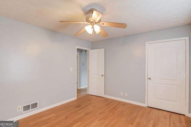 unfurnished bedroom with light wood-type flooring, visible vents, ceiling fan, and baseboards