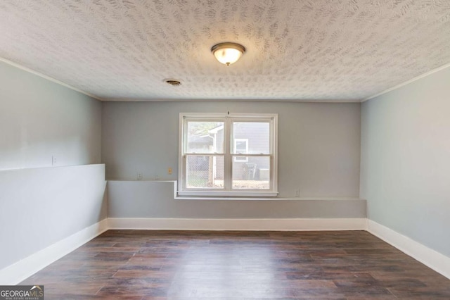 unfurnished room with dark wood-style flooring, a textured ceiling, and baseboards