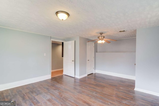 empty room featuring ceiling fan, a textured ceiling, wood finished floors, and baseboards