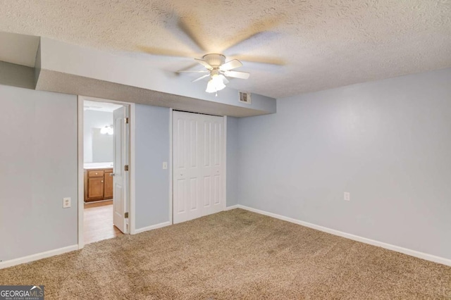 unfurnished bedroom featuring carpet, a closet, visible vents, a textured ceiling, and baseboards