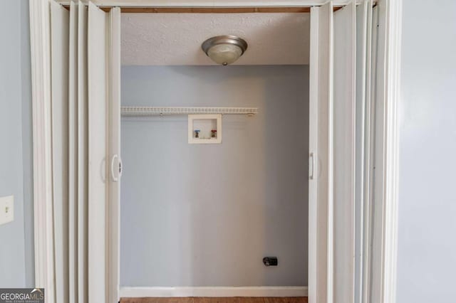 clothes washing area featuring a textured ceiling, laundry area, washer hookup, baseboards, and electric dryer hookup