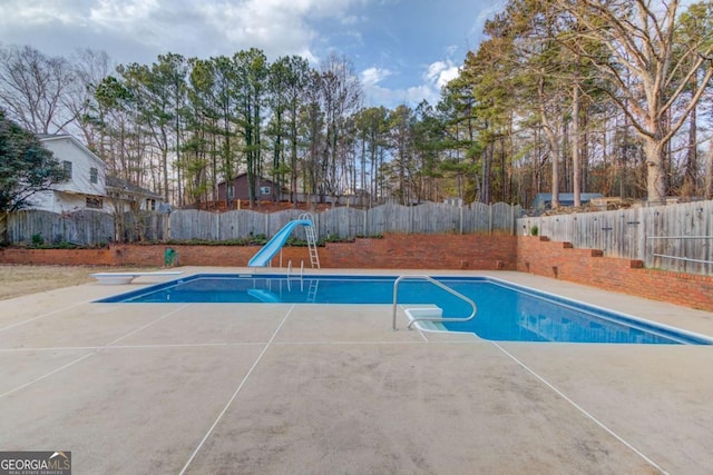 view of pool with a fenced backyard, a fenced in pool, and a water slide