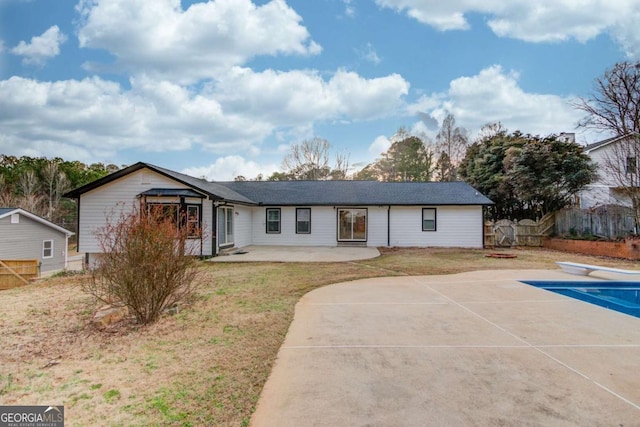 view of front facade with a front lawn, a patio area, fence, and a fenced in pool