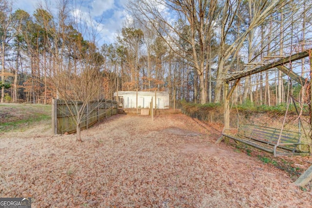 view of yard featuring an outbuilding, a storage shed, and fence