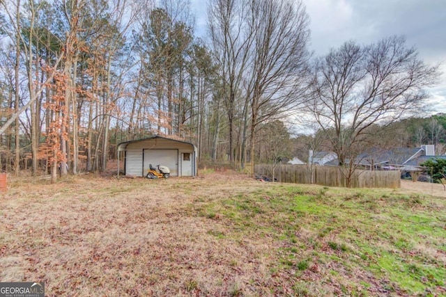 view of yard with a garage, an outdoor structure, and fence