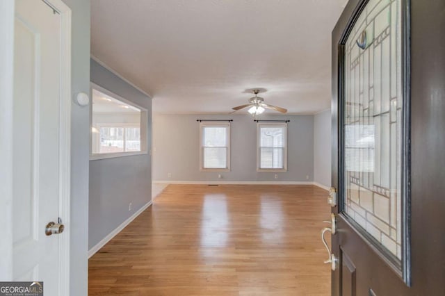 foyer with ceiling fan, light wood-style flooring, and baseboards