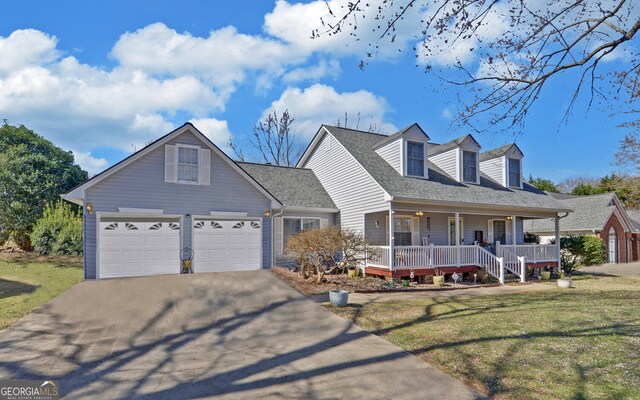 cape cod-style house with driveway, a garage, a shingled roof, a porch, and a front lawn