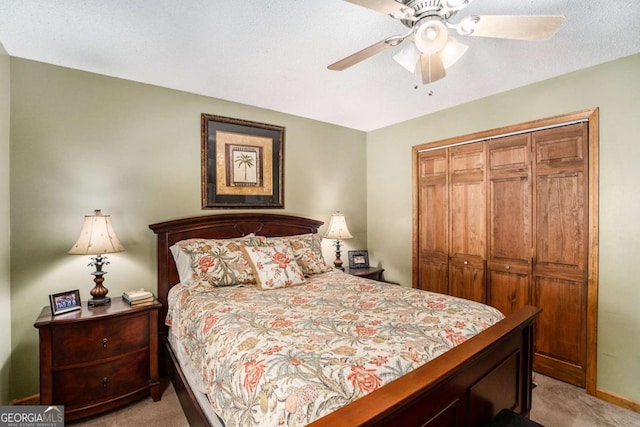 carpeted bedroom featuring a textured ceiling, ceiling fan, and a closet