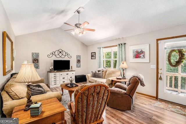 living room with lofted ceiling, a textured ceiling, ceiling fan, and light hardwood / wood-style flooring