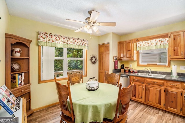 dining area with sink, a textured ceiling, ceiling fan, and light wood-type flooring