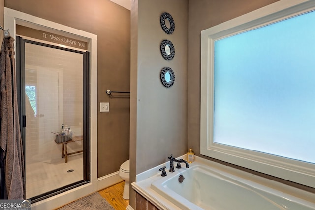 bathroom featuring wood-type flooring, shower with separate bathtub, and toilet