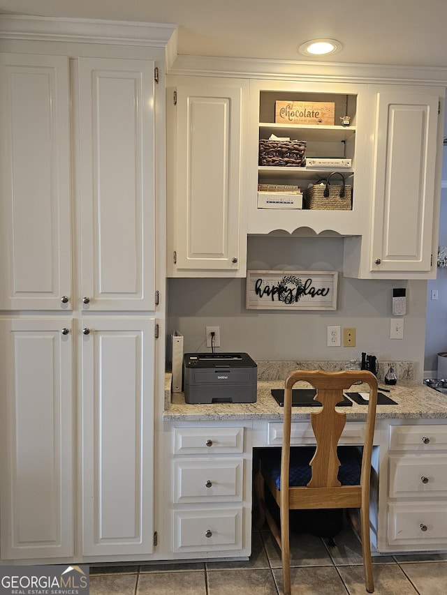 kitchen with white cabinetry, light tile patterned flooring, and light stone counters