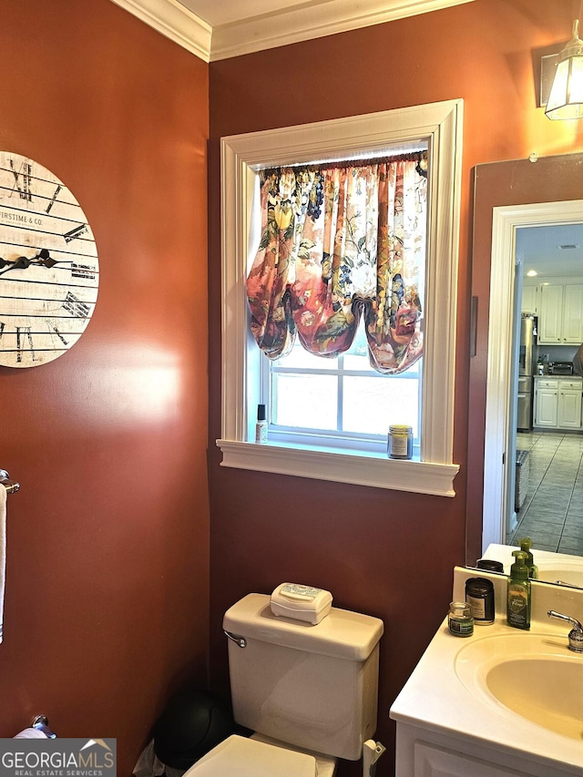 bathroom with ornamental molding, vanity, and toilet