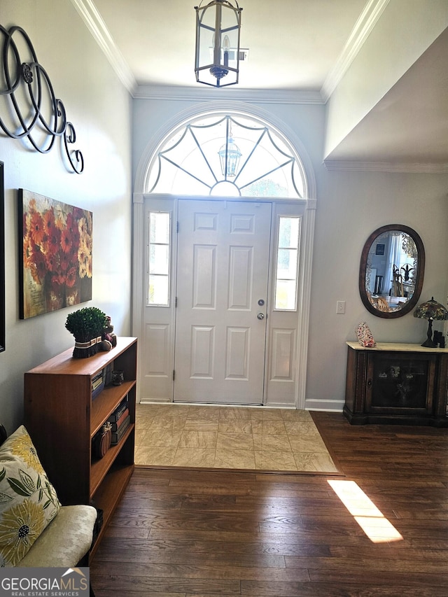 entryway with a healthy amount of sunlight, dark hardwood / wood-style floors, and ornamental molding