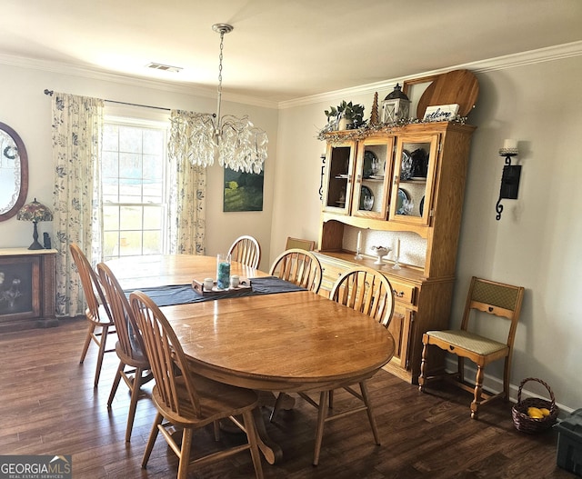 dining space with a notable chandelier, dark wood-type flooring, and ornamental molding