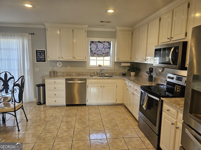 kitchen with white cabinetry, appliances with stainless steel finishes, sink, and crown molding