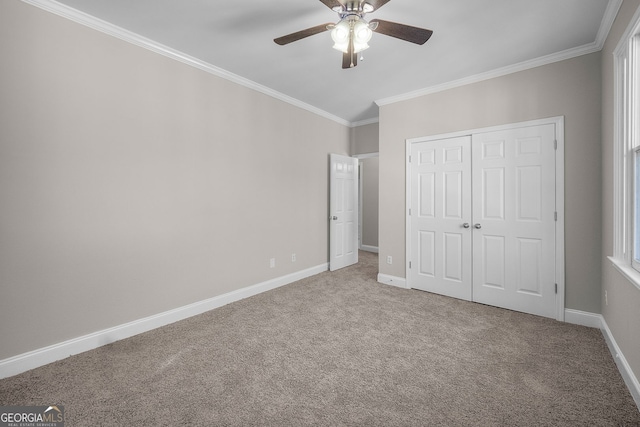 unfurnished bedroom featuring crown molding, a closet, ceiling fan, and carpet