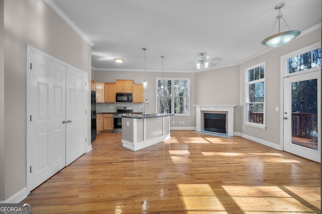 kitchen with light hardwood / wood-style flooring, a kitchen island with sink, pendant lighting, and black appliances