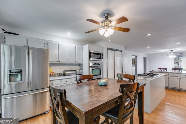 kitchen with ceiling fan, appliances with stainless steel finishes, and light hardwood / wood-style flooring