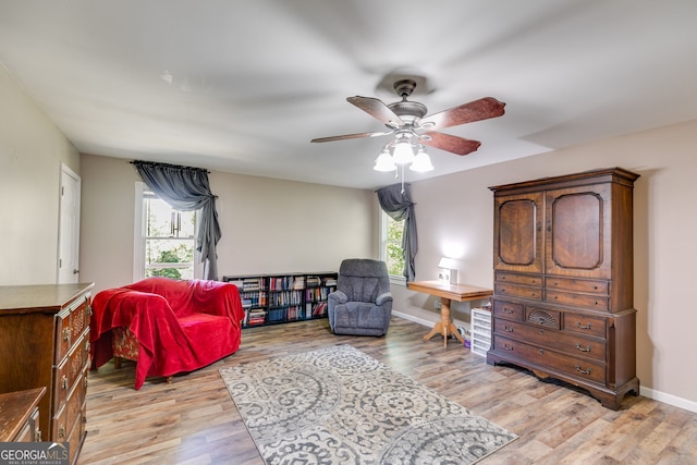 living area with ceiling fan and light wood-type flooring