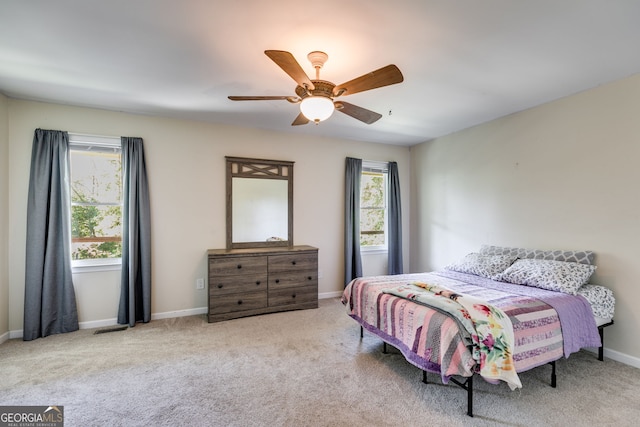 carpeted bedroom featuring multiple windows and ceiling fan