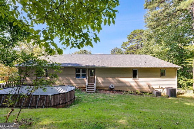 back of property featuring a yard and central air condition unit