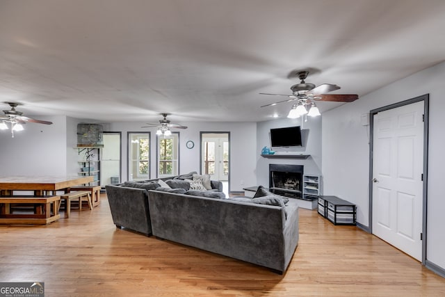 living room featuring ceiling fan and light hardwood / wood-style floors