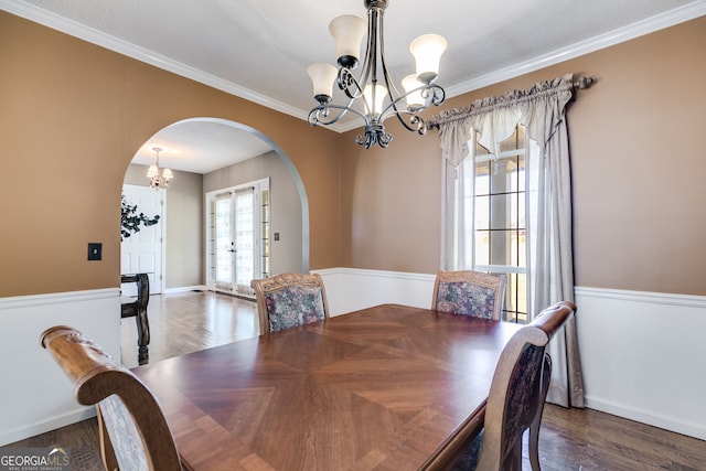 dining room with crown molding, dark hardwood / wood-style floors, and a chandelier