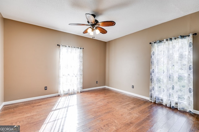 unfurnished room with ceiling fan, a textured ceiling, and light hardwood / wood-style floors