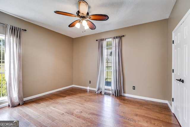 spare room featuring a textured ceiling, ceiling fan, and light hardwood / wood-style flooring